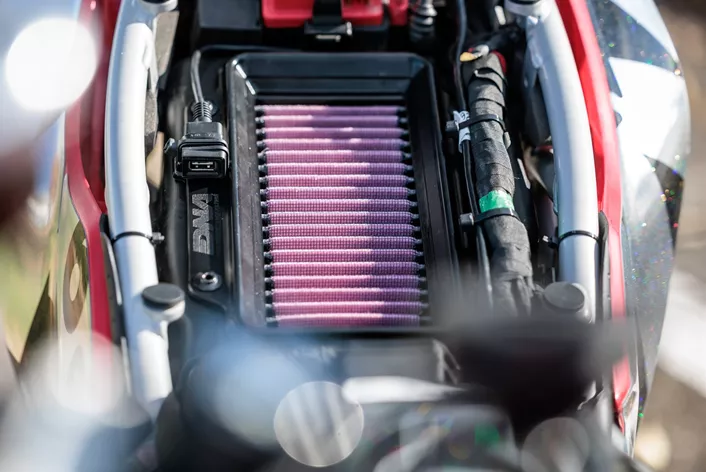 In essence, a racing air filter increases airflow, enhancing both engine performance and throttle response. However, beware that low-quality aftermarket air filters might result in reduced filtration efficiency and a lean air-fuel mixture.