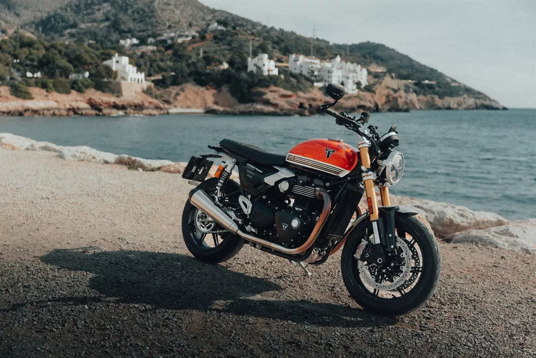 Barcelona, viel Sonnenschein, kurvige Bergstraßen – eine perfekte Kulisse für ein Motorrad, das den Spagat zwischen klassischer Eleganz und sportlicher Fahrdynamik wagt. Ich habe die Triumph Speed Twin 1200 RS mit dabei, um zu sehen, ob sie mehr ist als nur ein schicker Roadster für den Café-Besuch. Wie schlägt sie sich im längeren Gebrauch?