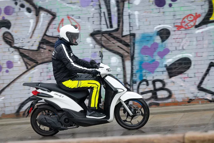 Een scooter is zelden het object van verlangen, maar eerder een werkpaard, een (hopelijk) praktisch apparaat om van A naar B te komen. Alleen Vespa heeft met zijn kleinhielige scooters een hype weten te creëren. In Duitsland en Oostenrijk verkopen Vespa's beter dan waar ook ter wereld - in verhouding tot het aantal inwoners. Maar als je door Rome, Milaan of Turijn rijdt, zie je niet zoveel Vespa's, maar veel meer Piaggio Libertys. Deze grootwiellscooter (voor 16 inch, achter 14 inch) staat mijlenver verwijderd van de cultstatus van zijn zustermodel uit dezelfde groep, maar kunnen duizenden Italianen echt ongelijk hebben? We komen er zelf achter in Milaan, tijdens de officiële persrit, in de regen, over gladde kasseien en straten die meer op wasborden lijken dan de buiken van Men’s Health-covermodellen.