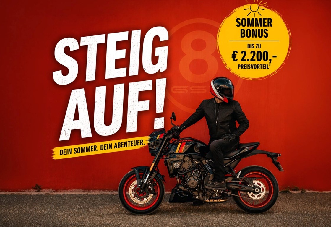Suzuki Sommerbonus 2026: Steig auf! – Fahrer auf einer Suzuki vor roter Wand