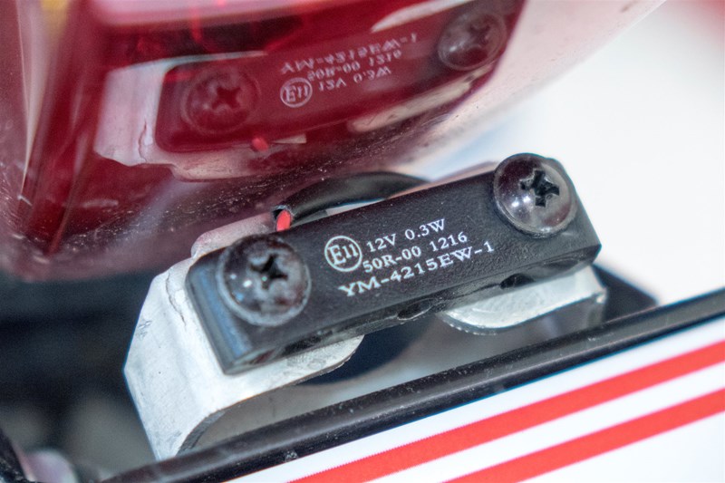 Ein ECE-Prüfzeichen auf einer Kennzeichenbeleuchtung.