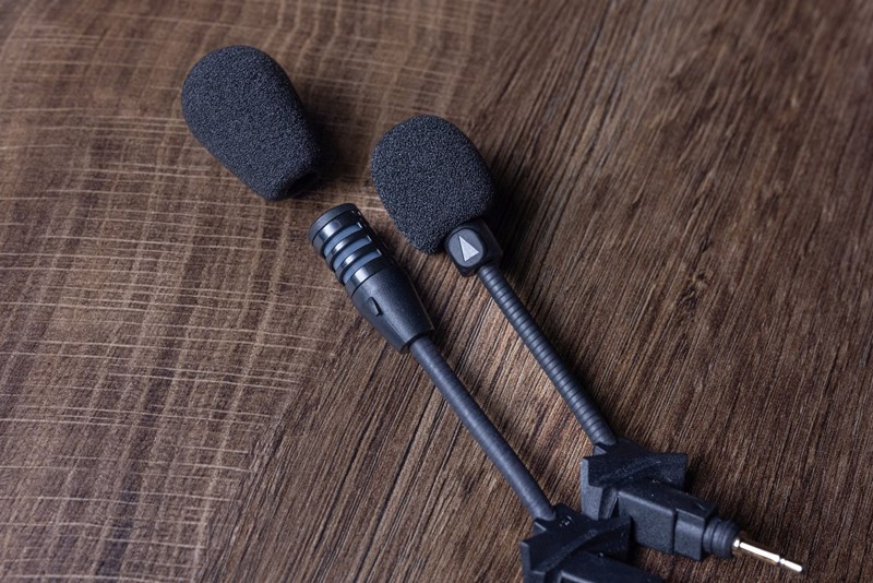 Einer der wenigen, handfesten Unterschiede: Das Cardo Mikrofon ist stark gerichtet (erkennbar am kleinen Pfeil, der in Richtung Mund zeigen muss), was bessere Sprechqualität bei lauten Nebengeräuschen ermöglicht.