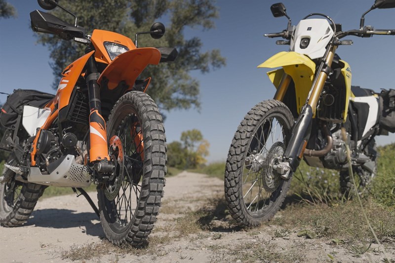 Die IRC Trailwinner Serienreifen der Suzuki sind okay, aber mit ihrer runden Kontur doch recht limitierend im Gelände. KTM setzt hier zumindest auf bewährte Metzeler Karroo 4 Pneus.