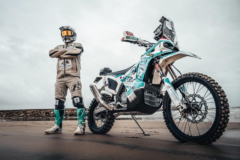 Luca Seppele in voller Montur und mit seiner Kove 450 Rally EX an der Seite.