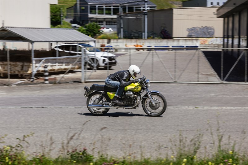 Sportposition aus einer Zeit, in der ein Café Racer wirklich auf Tempo ausgelegt war. Max im Sattel der V7 Sport von 1972, mit Blick über den langen Tank in die nächste Kurve.