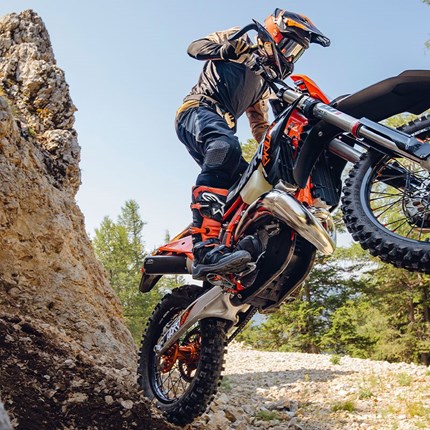2027 KTM 300 EXC HARDENDURO Leicht, kraftvoll und für härtestes Terrain gebaut: Die KTM 300 EXC HARDENDURO wurde für extreme, technisch anspruchsvolle Enduro-Bedingungen entwickelt. Ihr reaktionsschneller 2-Takt-Motor trifft auf ein präzises, agiles Fahrwerk und sorgt an steilen Anstiegen, in felsigen Passagen und in unberechenbarem Terrain für außergewöhnliche Traktion, Kontrolle und Souveränität. Die KTM 300 EXC HARDENDURO baut auf der bewährten KTM 300 EXC-Plattform auf, die weiterhin als Maßstab für technische Enduro-Performance gilt, und entwickelt dieses Erfolgsrezept konsequent für extreme Bedingungen weiter. Im Vergleich zum Standardmodell verfügt die KTM 300 EXC HARDENDURO über ein speziell entwickeltes Race-Paket für Fahrer, die sich den härtesten Bedingungen der Welt stellen. Der markante orangefarbene Rahmen und das spezielle HARDENDURO-Komponentenpaket unterstreichen ihren kompromisslosen Factory-Anspruch unter Extrembedingungen.