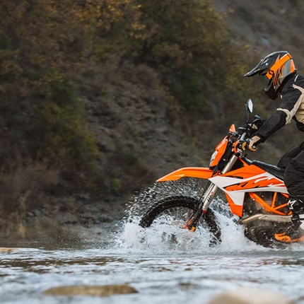 2027 KTM 690 Enduro R Stell dir vor: Mit steigender Drehzahl grollt deine KTM 690 ENDURO R, während die Vorstadt langsam hinter dir verschwindet. Vor dir bahnt ein heller LED-Lichtkegel den Weg durch den frühen Morgennebel, während du auf die nächste Schotterpiste zusteuerst. Wenig später tauchst du in die Wildnis ein und wechselst mühelos von Asphalt auf Schotter. Genau das macht die KTM 690 ENDURO R aus: grenzenlose Vielseitigkeit.
